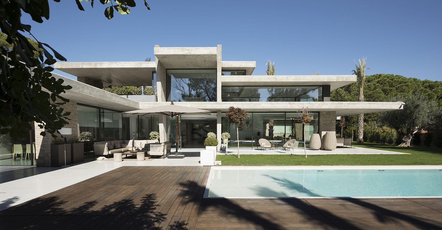 Casa de hormigón con grandes ventanales y conexión con el jardín