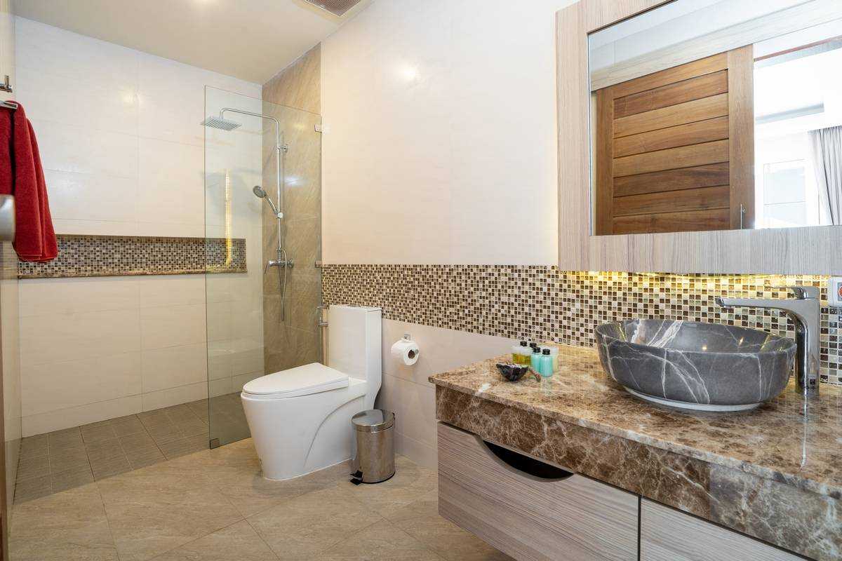 Sink with top granite, toilet and shower in a house