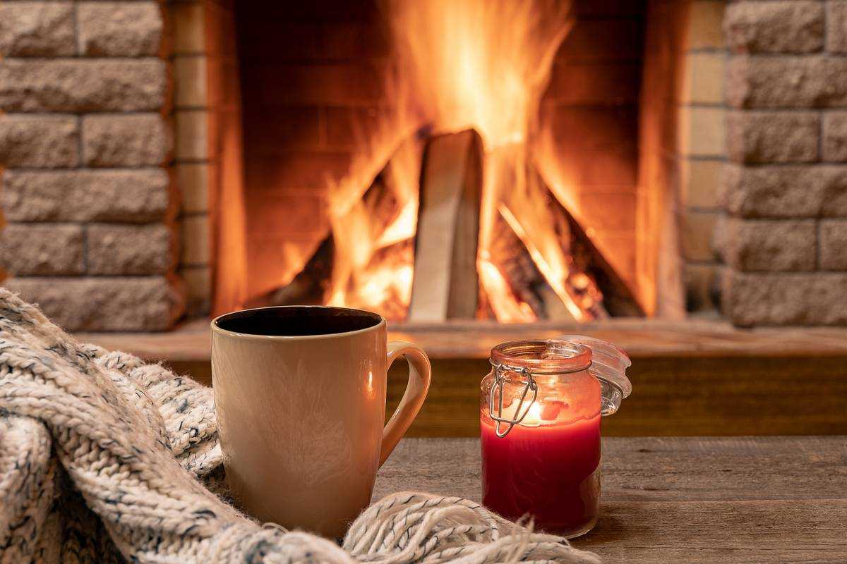 Candle & tea near cozy fireplace